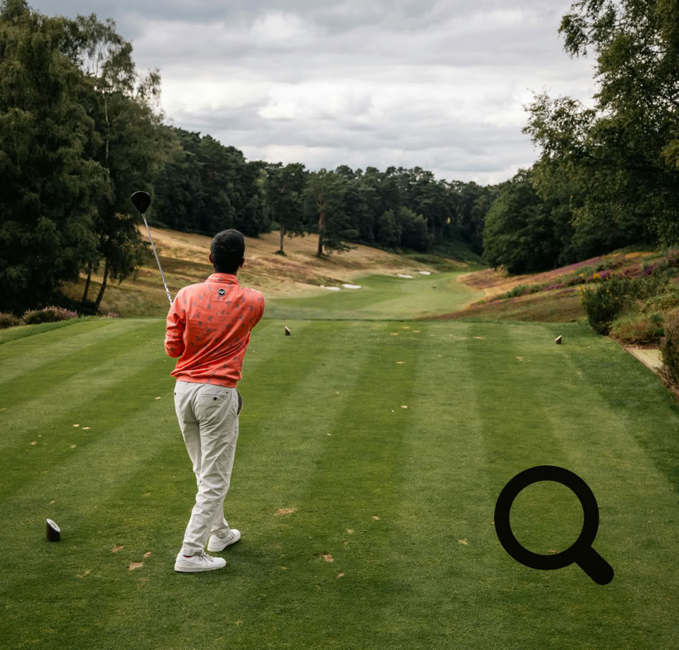 Golfer in Aktion auf einem malerischen Golfplatz in England bei bewölktem Himmel.